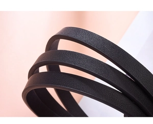 Close-up of black leather waist belt showing fine texture and premium edge stitching