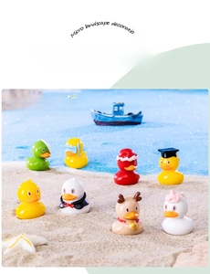 Miniature yellow duck figurines in beach scenery for DIY micro landscape decor