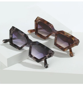 Detail view of irregular geometric sunglasses with tortoiseshell and marble texture frames