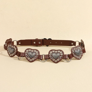 Macro detail of brown leather belt with heart-shaped metal rings and silver studs