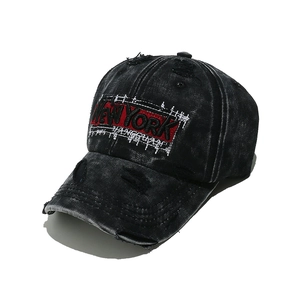 Close-up of New York embroidery on vintage washed black baseball cap with distressed edge