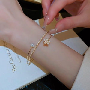 Elegant gold double-layered open bangle with pearl, flower, and zircon stone details
