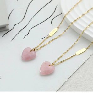Detail of pink crystal heart pendant necklace and Lucky engraved tag in 18K gold plated steel