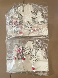 Close-up of wooden Christmas ornaments with red beads and twine in clear packaging