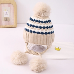 Primer plano del gorro de punto beige con orejeras, puntos coloridos y pompones suaves