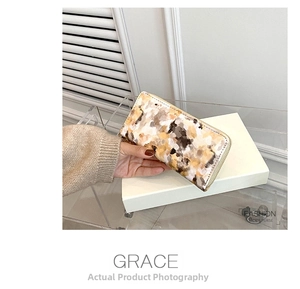 Macro view of long women's wallet with marble oil painting texture and gold zipper