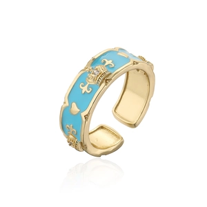 Macro shot of 18K gold plated crown ring with light blue enamel and fleur-de-lis detail