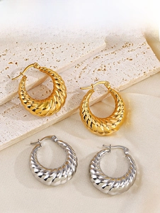 Détail des boucles d'oreilles créoles torsadées en or 18K et argent sur pierre et soie