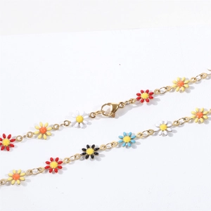 Detailed close-up of colorful enamel daisy charms on a delicate 18K gold-plated chain