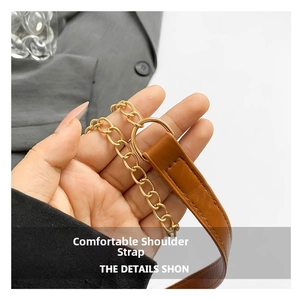 Detail showing brown leather shoulder strap with golden metal chain and stitching
