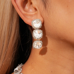 Close-up of three-tier silver pendant earrings with brilliant cut sparkling crystals