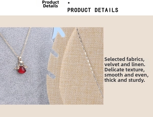 Macro detail of red angel pendant necklace on professional gray velvet jewelry display stand