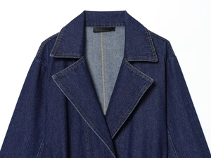 Détail du col d'une veste en jean montrant la texture du denim et les surpiqûres