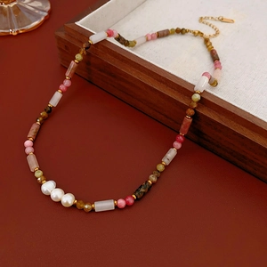 Detail view of colorful beads and freshwater pearls on a gold chain necklace