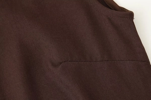 Close-up of the dark brown fabric showing twill texture and stitching on the dress