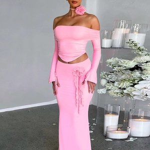 Pink two-piece ribbed knit set with off-shoulder top, maxi skirt and 3D floral choker