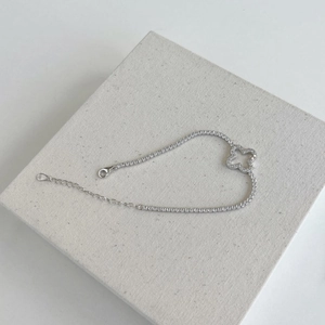 Close-up of S925 sterling silver tennis bracelet with clover charm and zircon stones