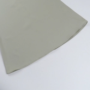 Close-up of the double-stitched hem on the off-shoulder mesh midi dress in sage green