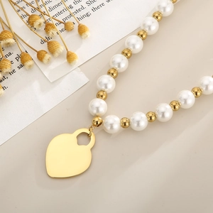 Elegante goldene Perlenkette mit weißen Perlen und einem minimalistischen Herzanhänger