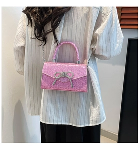 Vue détaillée d'un sac à main rose pailleté avec une boucle nœud en strass argent