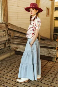 Gonna lunga in denim a tre strati abbinata a stivali western e un cappello da cowboy vintage