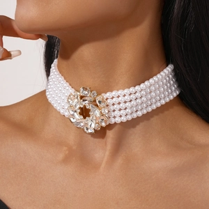 Gros plan d'un choker à cinq rangs de perles avec pendentif fleur en cristal doré