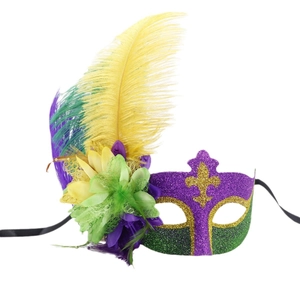 Festive masquerade mask with purple green gold sequins and feathers on white background