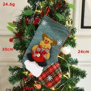 Green burlap Christmas stocking with reindeer doll and red-black plaid detail