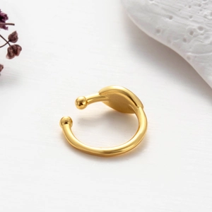 Detailed view of adjustable gold-plated geometric ring with spherical ends on white texture