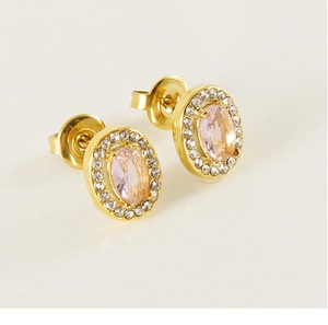Macro shot of gold stud earrings with oval pink main stone and pavé zircon border
