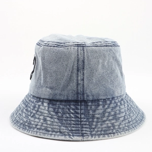 Gros plan détaillé sur le tissu denim délavé bleu clair et la broderie noire sur le chapeau