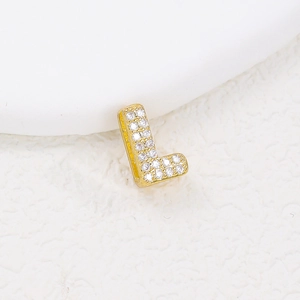 Macro shot of gold letter L pendant with cubic zirconia inlay and sparkling stones