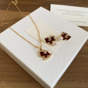 Detail of gold-plated pony jewelry set with red enamel, sparkling zircons and white pearls