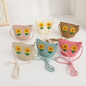 Dettaglio di borse a tracolla in paglia per bambini fatte a mano con fiori di girasole