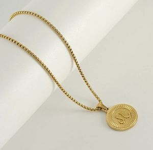 Vue détaillée du pendentif zodiaque Lion en or 18K sur une chaîne maille vénitienne