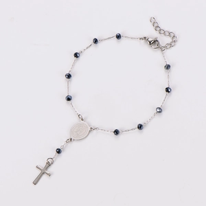 Detail of silver stainless steel chain bracelet with black beads and religious cross charm