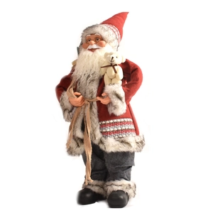 Detail of plush Santa Claus figure with gift bag and bear for holiday decor
