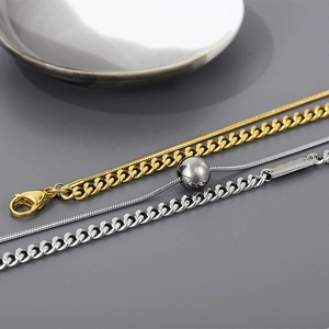 Vue détaillée de colliers superposés dorés et argentés avec pendentifs carrés et perles