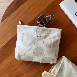 Detail of cream cotton linen pouch with textured polka dots and simple wish label