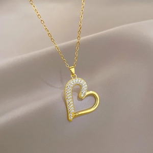 Detailed close-up of a gold heart pendant with sparkling crystals on an O-chain necklace