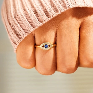 Adjustable S925 sterling silver evil eye ring with blue zircon stones on model's finger