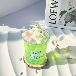 Detail of green jelly candle with cream topping and pink heart on wood base