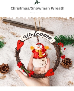 Detail of Christmas wreath with a plush snowman, red berries and welcome sign