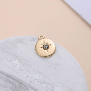 Detail of gold-plated starburst pendant with crystal on marble display stand
