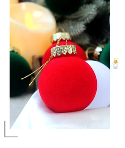 Vue macro d'une boule de Noël floquée rouge avec capuchon doré et accessoires de fête