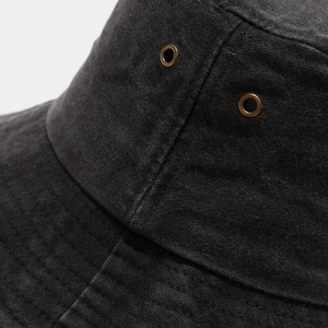 Détails des œillets métalliques et coutures renforcées sur le chapeau bob en coton lavé