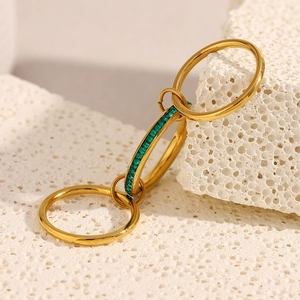 Macro view of 18K gold plated triple layered ring set with emerald green cubic zirconia