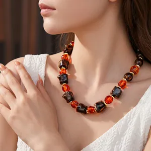 Vintage beaded necklace with irregular brown and amber beads on a model's neck