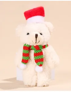 Detailed view of a plush Christmas teddy bear with red hat and striped knit scarf