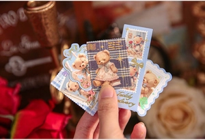 Close-up of vintage teddy bear stickers with scalloped edges for scrapbooking
